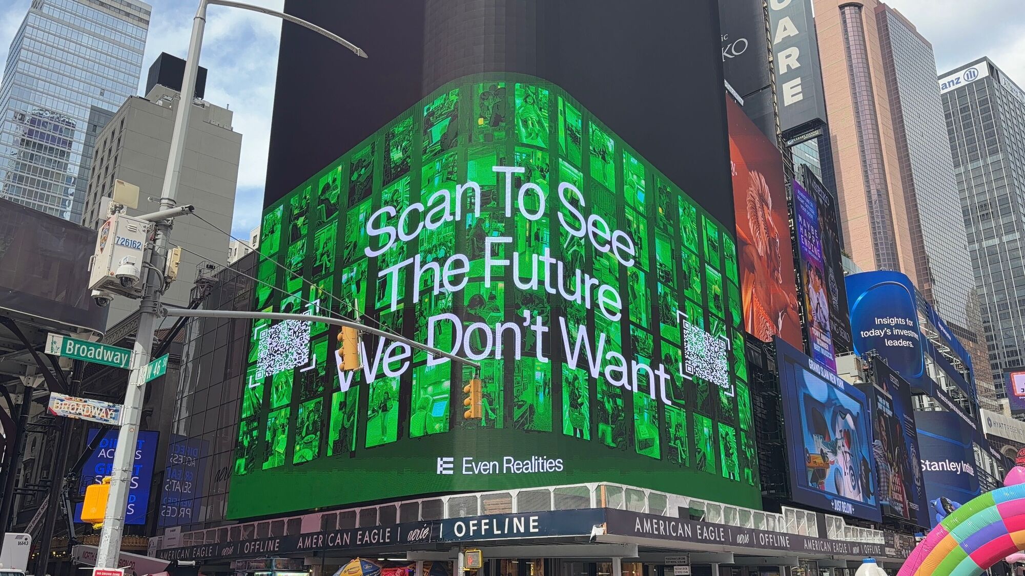 A bright green Even Realities digital billboard appears among the surrounding towers and screens in Times Square.
