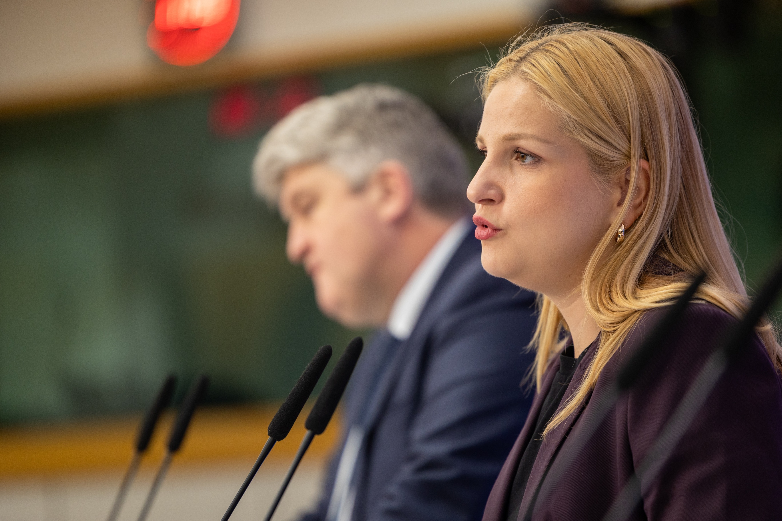 Arba Kokalari speaks at a microphone, with Michael McNamara beside her, at the 7 May AI Omnibus press conference.